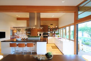 Throughout the house, Woolsey opened up confined rooms to create spacious areas where the family can live and play together. One example is shown here, where she expanded the kitchen by connecting it to a banquet breakfast area.