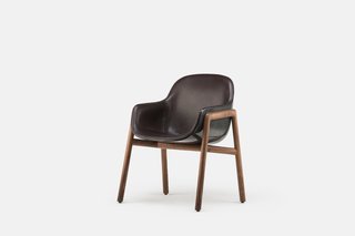 Along with the black-on-black option shown here, the Stella Armchair is also available in white, with the option to have either color in a glossy or matte finish. For additional freedom, the inner upholstery can be done in various different kinds of fabric or leather, while the base can be fitted with American black walnut (as shown here) or a lighter European ash. 