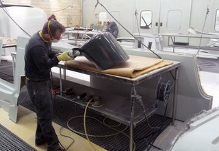 The pieces are designed in Italy and manufactured in Portugal, where De La Espada’s workshop is known for their high-quality woodworking skills. Shown here is a craftsman at work, carefully sanding the fiberglass shells that are fabricated through multiple steps—from forming a mold to the final piecing together. 