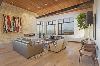 This modern mountain escape is outfitted with cutting-edge technology and sits seamlessly within the landscape of Woodland Hills, Utah. Its immense vistas are accentuated by a sleek fireplace that’s surrounded by a more organic placement of stone. 