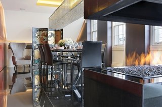 Overlooking London’s St. James’s Park, the penthouse of the Carlton House Terrace features 24-hour security and a private entrance with a concierge desk. Elevator access leads you to this renovated residence where the open stacked fireplace takes command of the dining room. 