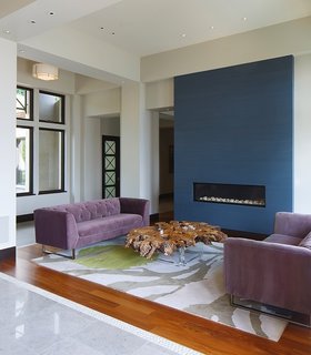 A closer look at the living space near the entrance reveals a modern fireplace that’s built into a blue accent wall. 