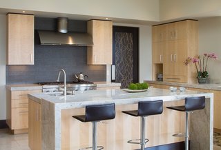 The kitchen features a waterfall counter made of the same marble that covers the rest of the surfaces. 