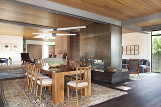 When you enter the interior, you’ll be able to freely wander between the living and dining areas, which boasts a Cor-Ten steel fireplace that’s surrounded by hearth seating made of black marble. 
