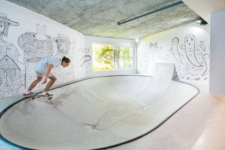 A fully functional concrete skate bowl plays a quintessential role in the layout of the space. The walls are lined with custom art by South African street artist Jack Fox.