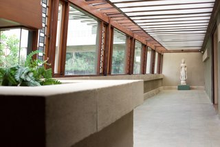 Since Wright was simultaneously working on the Japanese Imperial Hotel, he incorporated many Japanese details in the design of the Hollyhock House. Along with the Japanese screens in the living room, there's also a Buddhist sculpture at the end of a long hallway that’s lined with art glass.