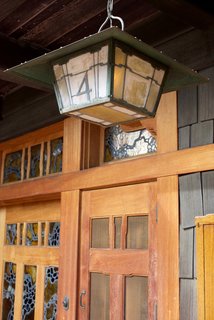 The home is surrounded by open porches that are constructed of cedar. The house’s art glass—shown here on the front door—acted as a way to bring light into the space before there was electricity. 