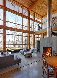 Bringing the Outdoors in Becomes a Reality for a Lakeside Retreat - Photo 2 of 2 - To complement the house’s timber frame and its extensive ceiling decking, the team chose to line the substantial window wall with a pine treatment that would give them the freedom to combine various size units. 