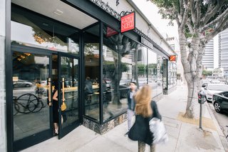 The new location is located in the Westwood neighborhood of Los Angeles, which supersedes the first version being posted in Downtown L.A. The expansive front windows ensure that the the space feels connected to the neighborhood. They stand above a marble border that's part of the existing building's facade. 