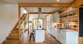 Dwell Home Tours Makes its Way to Portland - Photo 2 of 17 - The interior is filled with a range of salvaged woods. Throughout the space, you’ll find floors made of white oak from Oregon, reclaimed red oak, and cork. The open kitchen features quartz counters, an induction cooktop, and salvaged wood accents. 