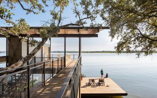 Take it Outside With These 11 Spring-Friendly Deck Spaces - Photo 10 of 11 - The three-story Blue Lake Retreat is located in Marble Falls, Texas. The residence was designed by Lake Flato Architects to integrate naturally into the steep topography. With living spaces on the top floor and four bedrooms on the two lower floors, the timber structure is connected to the hillside by a bridge and boasts a cantilevered deck that floats just above the lake. 