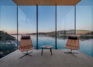 The large expanses of glass were designed specially to frame the seaside views. To fit with the minimal aesthetic of the cabins, the seating areas are furnished with Scandia lounge chairs that were designed by Hans Brattrud in the 1950s and that are now being produced by Fjordfiesta.