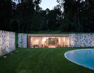 Taking a peek into the new pool house that helps enclose the area, you can see how the sloped land and the original stone walls allow it to remain surprisingly hidden from the outside. 