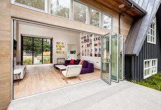 Dwell Home Tours Lands in Silicon Valley - Photo 2 of 15 - The second A-frame includes one end that’s made up entirely of glass. It houses a spacious room that incorporates a kitchen, living room, and dining room. 