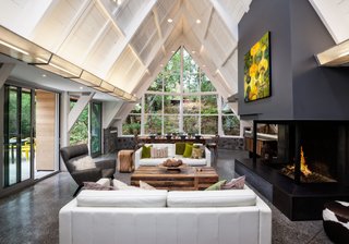 Dwell Home Tours Lands in Silicon Valley - Photo 3 of 15 - Looking from the kitchen, this view reveals the attached living and dining rooms that take full advantage of the A-frame design. The structure itself is made up of local stone, redwood, and bleached cedar siding.