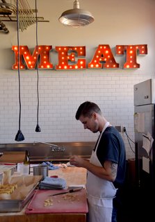 This Olympia Provisions location is hidden inside a restored industrial building in a part of town that’s held strong onto its industry-filled history. Visitors can take a peek into the kitchen where snacks and entrees are prepared under a glowing industrial "MEAT" sign. 