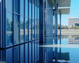 Take a Visual Exploration of a Floating Art Haven in Fort Worth, Texas - Photo 2 of 3 - The 40-foot-high glass and concrete walls are framed in metal and are topped with cantilevered cast-concrete roofs. If you visit the site, you'll find a reflecting pond, landscaped public areas, and an outdoor sculpture garden and terrace.