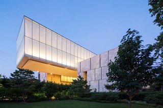 Tod Williams Billie Tsien Architects (TWBTA) built a cantilevered rectangular box that hovers over a courtyard. The new site is known as the "Gallery in a Garden."