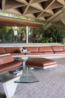 In the living room—which has become known as the "Big Lebowski Room"—boasts a curvy concrete-and-leather sofa that resulted from a collaboration between Goldstein and Lautner. The ceiling is covered with sandblasted concrete that still has the original miniature circular skylights.