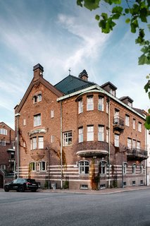The street view of the hotel shows its masonry structure and pitched metal roof, which is traditionally seen in Stockholm structures. The solid brick facade acts as a protective shield against Stockholm's bitter winters. 