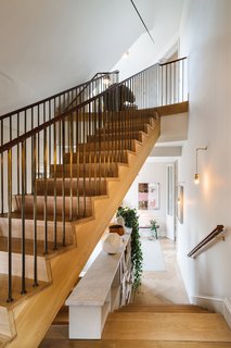 Though there’s a small elevator that leads to each floor, there’s also a wood-clad staircase with brass handrails that are wrapped with leather. You’ll also find the owners' personal collection of art and photography that's spread throughout each floor.