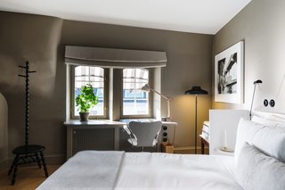 In this bedroom on the top floor, a desk area overlooks the Östermalm neighborhood and is equipped with heated floors. Each room also has its own brass cocktail cabinet.