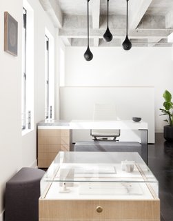 Above Lee’s custom desk hangs three matte black Drop Light Pendants that were designed by Early Work. 
