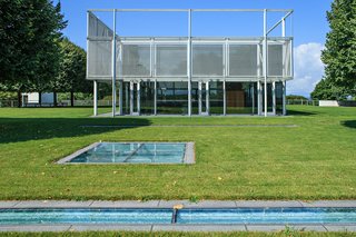 The house includes 7,000 square feet of substructure that sits on the underside of the hill from one side, and is open to the sky on the other. The glass plates seen at the forefront of this image serve as skylights to the substructure, which includes an indoor pool, mudroom, library, kitchen, gym, media room, and a walk-in cheese locker and wine room. 