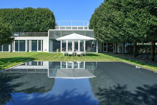 A large portion of the home is surrounded by green roof that sits above the substructure. The reflecting pool is shown here, which can be admired from the expansive kitchen's windows.