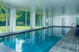 The substructure features an indoor pool, which looks out through glass walls on the side that's exposed to the ground level. 