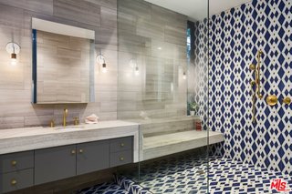 The master suite was completely updated with Carrera marble, travertine, and handmade encaustic tile that references elements of Stenger’s original design. 