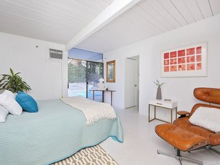 The house includes four bedrooms and two bathrooms, which have been updated. This bedroom exits directly onto the backyard patio.