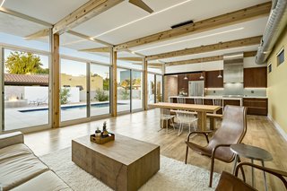 A Desert Oasis Awaits in a Historic District of Phoenix - Photo 2 of 2 - The wood beams and exposed brick from the exterior are reflected in the open living space, which also features a mix of natural surfaces and an exposed duct. 