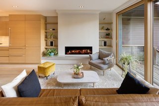 A Toronto-Based Firm Breathes New Life Into a Victorian’s Interior - Photo 2 of 3 - Thanks to a hidden screen that rolls down over the fireplace, the living room doubles as a TV or movie room. 