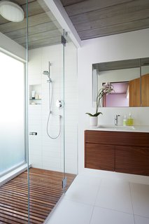 Same Bones, New Materials—A Double Gable Eichler Gets a Dashing Update - Photo 8 of 9 - The larger master bathroom was reoriented and updated with new materials—the same ones that have been used throughout the house, including walnut and Western red cedar siding. 