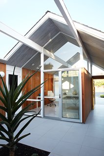 Same Bones, New Materials—A Double Gable Eichler Gets a Dashing Update - Photo 1 of 9 - As one of Eichler’s courtyard models, the home's office looks directly through the atrium and into the glass-enclosed living room, providing the ultimate indoor/outdoor feeling. The gray porcelain tile that Klopf Architecture installed in the interior is continued into the atrium. 