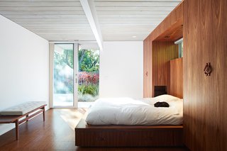 Same Bones, New Materials—A Double Gable Eichler Gets a Dashing Update - Photo 7 of 9 - To enlarge the bathroom, they combined it with the master bedroom's closet—and thus had to create new storage. So, they designed a custom walnut bed wall that contains built-in wardrobes. 