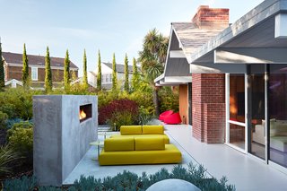 Outer Space Landscape Architects built a custom fireplace in the backyard, which acts as a backstop for the seating area.