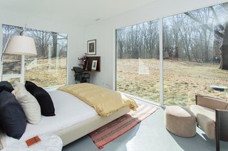 Red Cedar Is the Key Ingredient of This Wooded Cottage For Sale - Photo 6 of 8 - The bedrooms enjoy views of the wooded surroundings through large expanses of glass. 