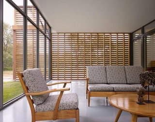 Red Cedar Is the Key Ingredient of This Wooded Cottage For Sale - Photo 5 of 8 - Shown here is the screened porch that looks out through glass on one side and screened red cedar slabs on the other. 