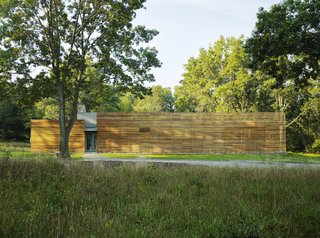 The Coffou Cottage sits in an L-shaped configuration at the end of a private road. This image shows how red cedar is utilized to create thin slats along the facade, as well as horizontal and vertical board-and-batten siding.