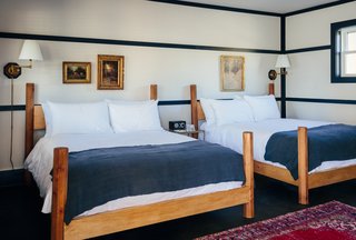 The twelve classic bedrooms are filled with raw brass light fixtures and beds that are custom designed by woodworker David E Cummings. Marked by octagonal posts, the frames are made out of solid pine and are handcrafted in his upstate studio. 