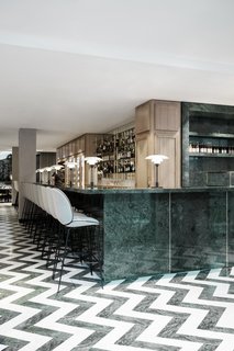 The Revived Maison du Danemark Brings Two New Danish Restaurants to Paris - Photo 5 of 9 - The entire space is filled with a green-focused color palette that’s offset by shades of gray and brass details. The expansive green marble bar hosts GUBI's Beetle Bar Stools.