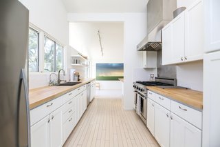 While the kitchen was updated with new surfaces and appliances, its original wood flooring has been kept intact.