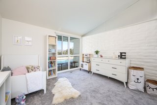 The bedroom that the current family turned into their daughter’s room has one original brick wall and looks out to views of the pool. 