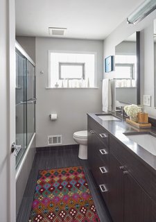 They gutted the bathroom on the second floor—which used to be filled with everything pink—and removed the existing linen closet in order to extend the vanity to fit two sinks. 