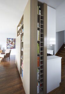 The installation of the dry bar made them realize they had a full wall that they could utilize for built-in cabinetry. Thus, they designed a three-sided built-in storage wall that they now use to hold wine, cookbooks, and vintage glassware that Carly collects. 