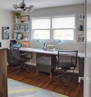 Carly uses one of the bedrooms upstairs as her office, which is furnished with movable Ikea desk tops that fit the extent of the wall. 