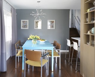 The dining room hosts a table that they found on Craig’s List, which Carly painted bright blue in the basement of her old apartment. 