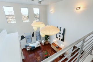 Shown here is the view of the living space from the lofted bedroom. The loft is being sold with a four-piece set of George Nelson bubble lamps that hang from the twenty-foot ceiling. 